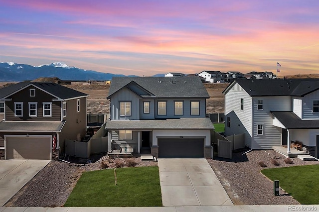 view of front of property with a residential view, concrete driveway, an attached garage, and fence