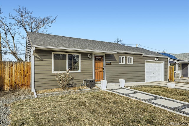 ranch-style house with a garage and a front lawn