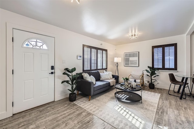 living room with hardwood / wood-style flooring and an AC wall unit