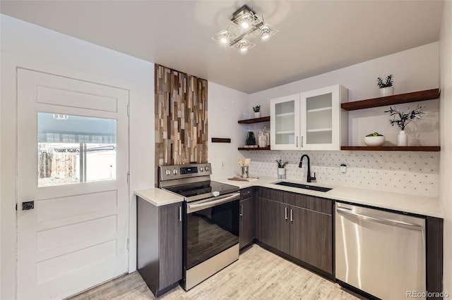 kitchen with sink, white cabinetry, stainless steel appliances, dark brown cabinetry, and decorative backsplash