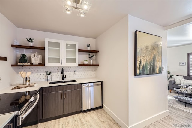 bar with sink, appliances with stainless steel finishes, backsplash, dark brown cabinets, and light hardwood / wood-style floors