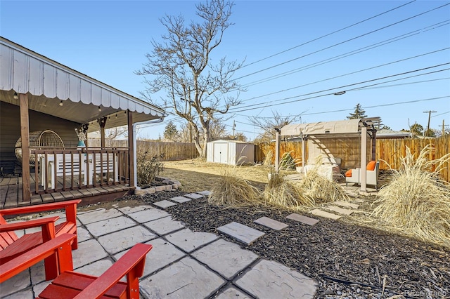 view of patio featuring a wooden deck and a storage shed