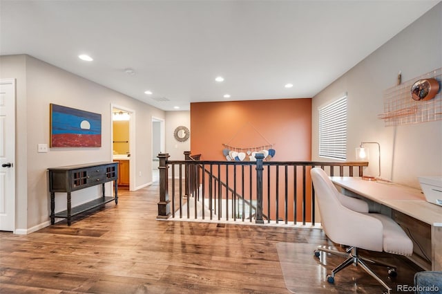 office space featuring built in study area, wood finished floors, baseboards, and recessed lighting