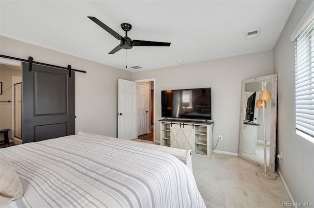 carpeted bedroom featuring multiple windows, visible vents, and a barn door