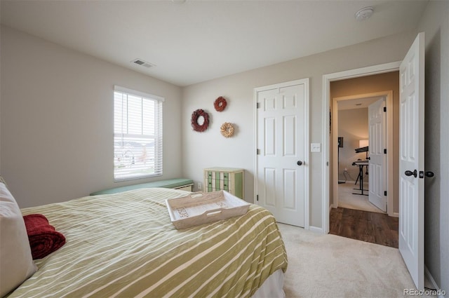 carpeted bedroom featuring visible vents