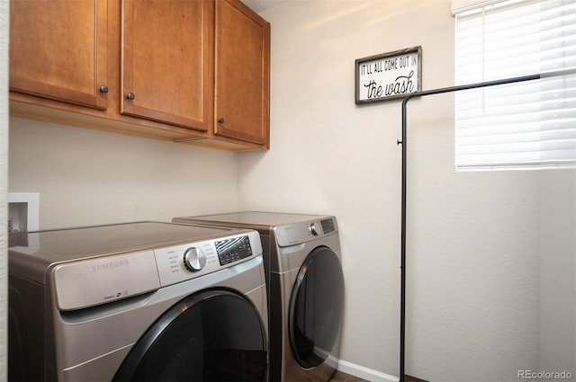 clothes washing area with washer and dryer and cabinet space