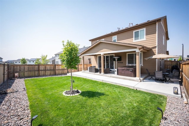back of house with a lawn, a hot tub, a patio area, and a fenced backyard