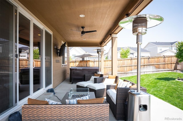 view of patio featuring a hot tub, outdoor lounge area, ceiling fan, a residential view, and fence private yard