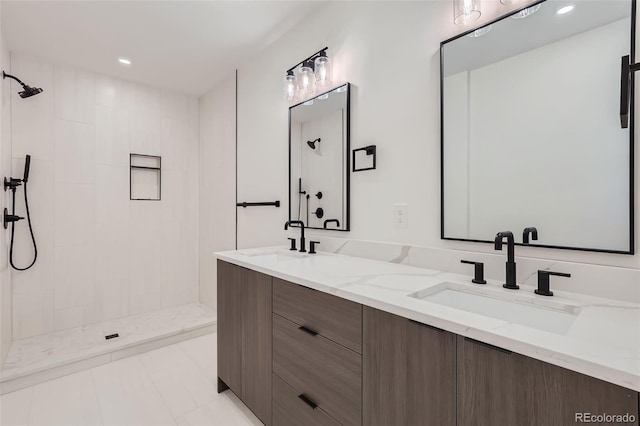 bathroom with tiled shower and vanity