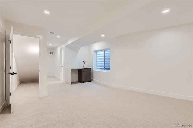 bonus room featuring sink and light carpet