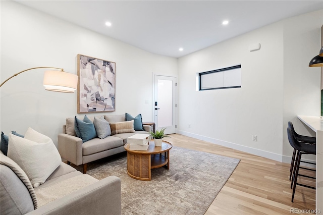 living room with baseboards, recessed lighting, and light wood-style floors