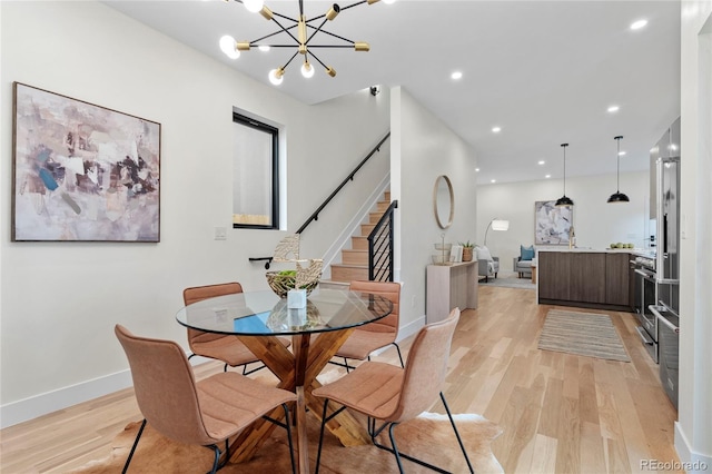 dining space featuring a chandelier, recessed lighting, baseboards, light wood-style floors, and stairway