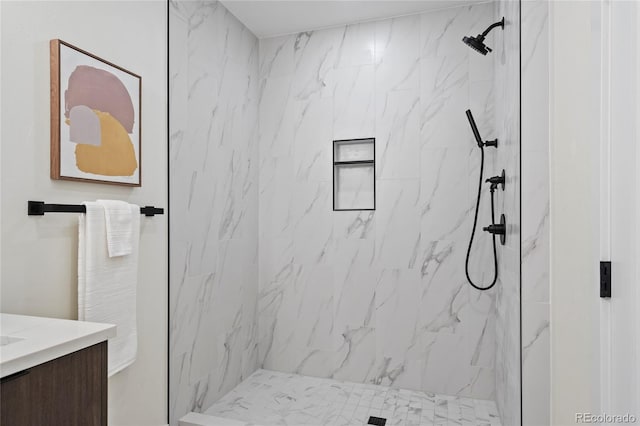 bathroom with a marble finish shower and vanity