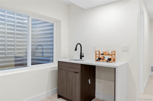 bar featuring a sink and baseboards