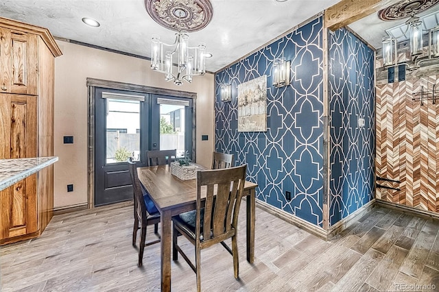 dining space featuring hardwood / wood-style flooring, a chandelier, ornamental molding, and french doors