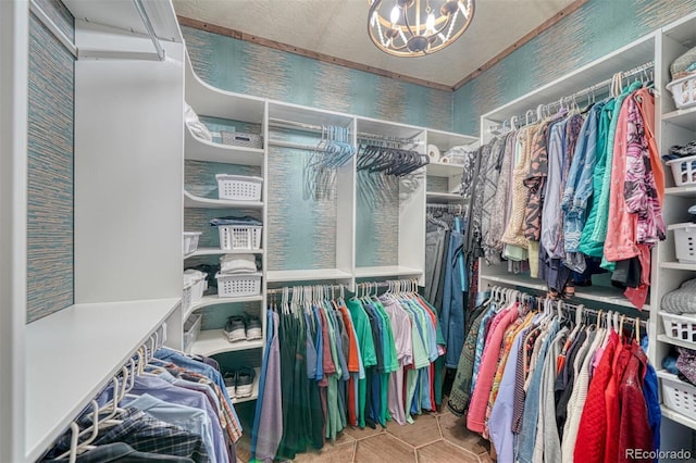 walk in closet featuring tile patterned floors and a notable chandelier