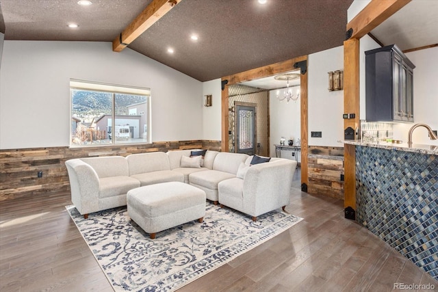 living room featuring dark wood-style floors, wainscoting, lofted ceiling with beams, and wooden walls