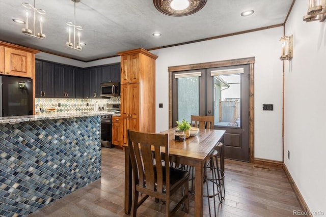 dining room featuring ornamental molding, french doors, dark wood-type flooring, and baseboards