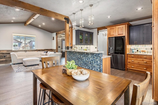 dining room featuring vaulted ceiling with beams, recessed lighting, and light wood-style floors