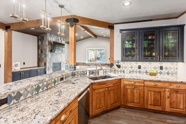 kitchen with brown cabinetry, glass insert cabinets, hanging light fixtures, stainless steel dishwasher, and a sink