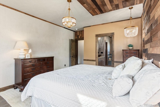 bedroom featuring crown molding, wood finished floors, and a notable chandelier