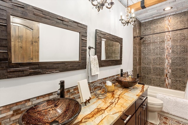 full bathroom with a chandelier, vanity, toilet, and shower / tub combo with curtain