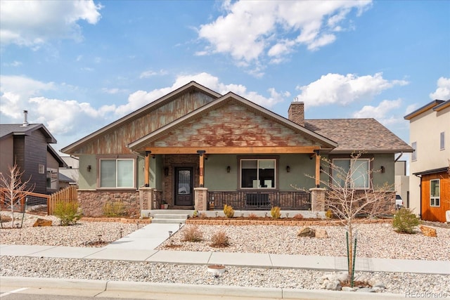 view of front of home with fence, covered porch, stone siding, stucco siding, and a chimney