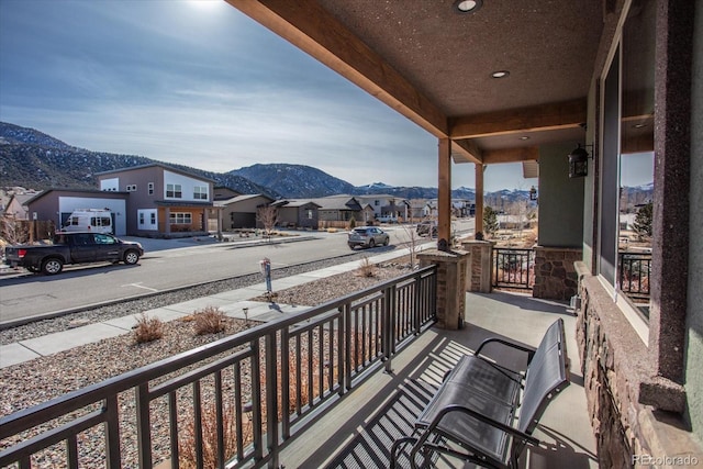 balcony with a porch, a residential view, and a mountain view