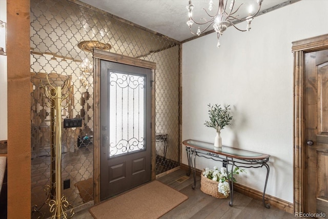 entrance foyer featuring baseboards, an inviting chandelier, and wood finished floors
