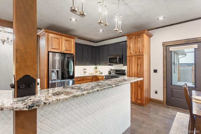kitchen featuring light stone countertops, light wood-type flooring, recessed lighting, a notable chandelier, and stainless steel appliances