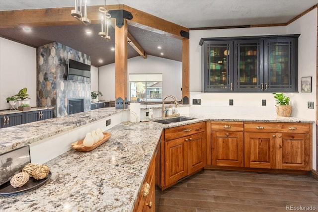 kitchen featuring a sink, lofted ceiling with beams, dark wood finished floors, and light stone countertops