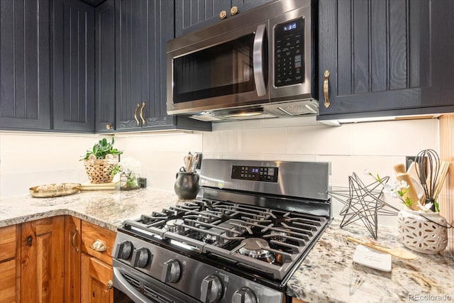 kitchen featuring stainless steel appliances, light stone counters, and tasteful backsplash