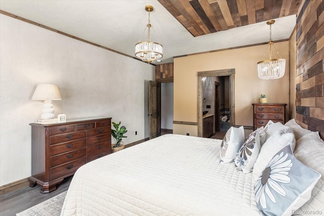 bedroom with baseboards, wood finished floors, and a chandelier