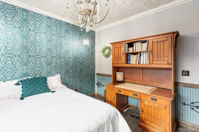 bedroom with an inviting chandelier, ornamental molding, dark wood finished floors, and wallpapered walls