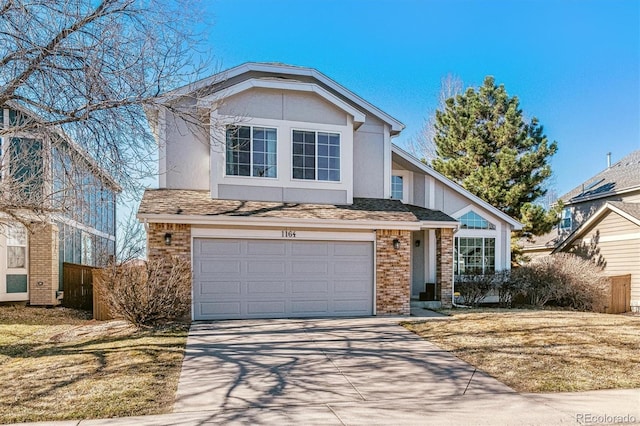 traditional home featuring stucco siding, concrete driveway, an attached garage, a shingled roof, and brick siding