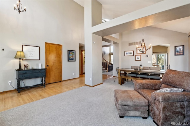 living room featuring stairway, wood finished floors, visible vents, carpet floors, and an inviting chandelier