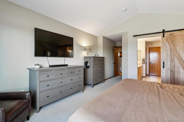 bedroom featuring light colored carpet, connected bathroom, lofted ceiling, and a barn door