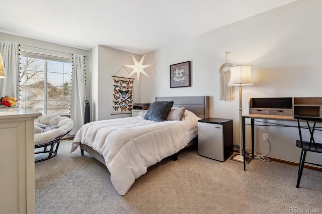 bedroom with fridge and light colored carpet