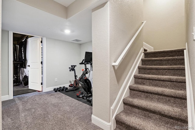 stairway with visible vents, baseboards, and carpet floors