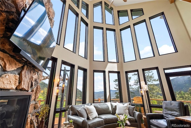 1194 Snyder Mountain Rd, Evergreen, CO 80439 - sunroom featuring plenty of natural light, a high ceiling, and a mountain view