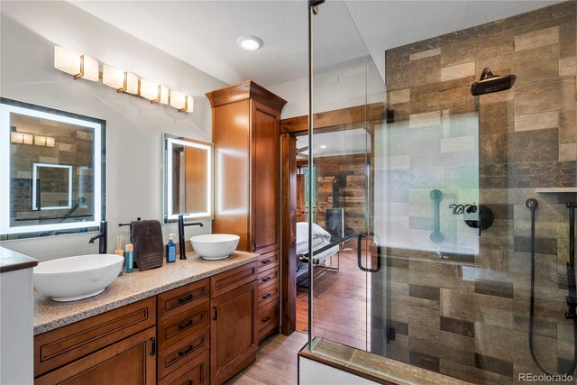 1194 Snyder Mountain Rd, Evergreen, CO 80439 - bathroom with a shower stall, double vanity, and wood finished floors