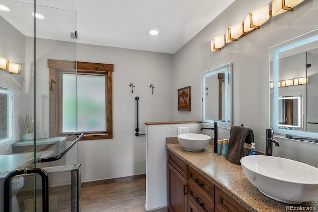 1194 Snyder Mountain Rd, Evergreen, CO 80439 - bathroom with double vanity, wood finished floors, a shower stall, and recessed lighting