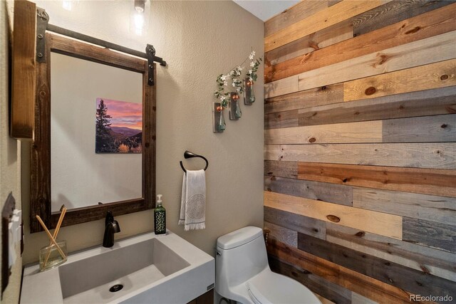 1194 Snyder Mountain Rd, Evergreen, CO 80439 - bathroom featuring wood walls, a textured wall, and vanity