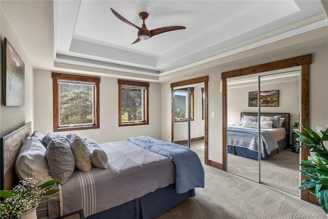 1194 Snyder Mountain Rd, Evergreen, CO 80439 - bedroom with a tray ceiling, multiple closets, light carpet, and a ceiling fan