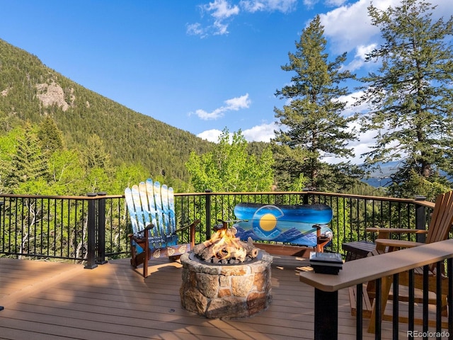 1194 Snyder Mountain Rd, Evergreen, CO 80439 - wooden deck featuring a fire pit, a wooded view, and a mountain view