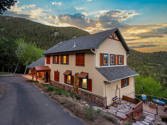 1194 Snyder Mountain Rd, Evergreen, CO 80439 - view of front of property with a forest view, stucco siding, and stone siding