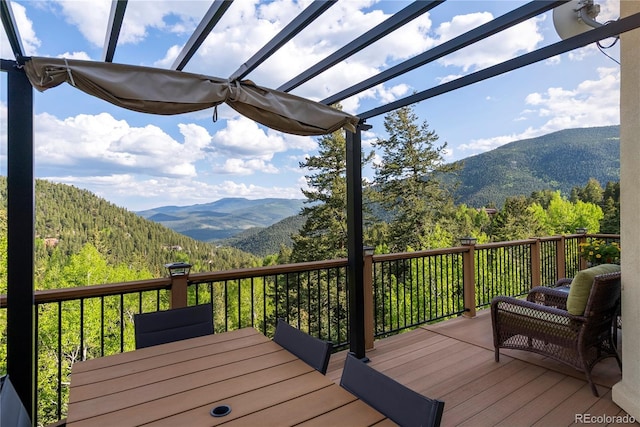 1194 Snyder Mountain Rd, Evergreen, CO 80439 - wooden terrace with a mountain view, a pergola, and a wooded view