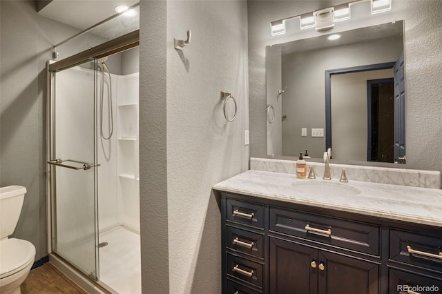 2754 County Rd 421, Florissant, CO 80816 - full bath featuring toilet, a shower stall, vanity, a textured wall, and wood finished floors