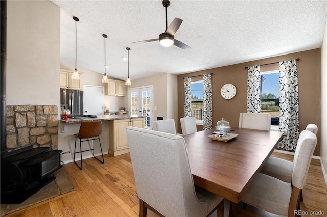 8804 Lariat Loop, Elizabeth, CO 80107 - dining area with a wood stove, light wood-type flooring, a textured ceiling, healthy amount of natural light, and a ceiling fan