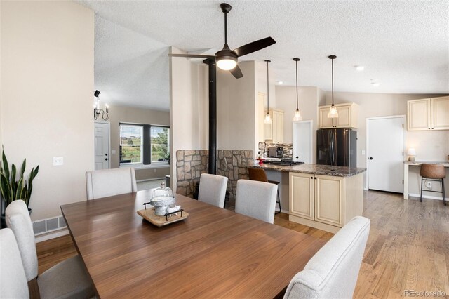 8804 Lariat Loop, Elizabeth, CO 80107 - dining room featuring light wood finished floors, a ceiling fan, a textured ceiling, and vaulted ceiling